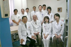 西出病院の西出巖会長（中央）と治療スタッフ